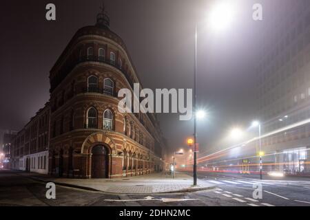 Traffic leaves light trails on Victoria Street outside Victorian 'Bristol byzantine' office buildings on a misty night in Bristol. Stock Photo