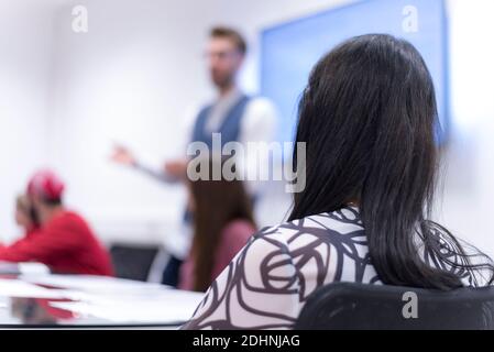 Business coach. Young man giving advices for small group of startup managers, explaining them how to grow their business Stock Photo