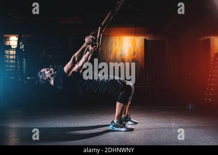young man has crossfit workout with trx in modern gym Stock Photo