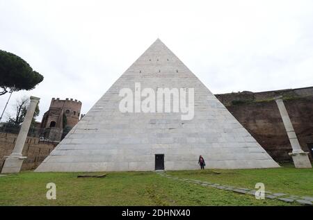 A view of the restored Pyramid of Cestius in Rome,Italy on February 3, 2016. Eternal City's only surviving pyramid dating from conquest of Egypt looks to attract more visitors after extensive clean-up funded by Japanese clothing magnate. Archaeologists are eager to show off the monument, constructed some 2,000 years ago as the burial tomb for a Roman praetor, or magistrate, named Caius Cestius. The pyramid is one of four known to have been built in ancient Roman days, but the only one to survive until today. Their construction reflected a fashion for Egyptian style in Rome after the conquest o Stock Photo