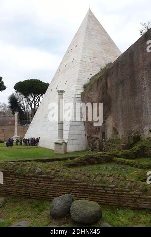 A view of the restored Pyramid of Cestius in Rome,Italy on February 3, 2016. Eternal City's only surviving pyramid dating from conquest of Egypt looks to attract more visitors after extensive clean-up funded by Japanese clothing magnate. Archaeologists are eager to show off the monument, constructed some 2,000 years ago as the burial tomb for a Roman praetor, or magistrate, named Caius Cestius. The pyramid is one of four known to have been built in ancient Roman days, but the only one to survive until today. Their construction reflected a fashion for Egyptian style in Rome after the conquest o Stock Photo