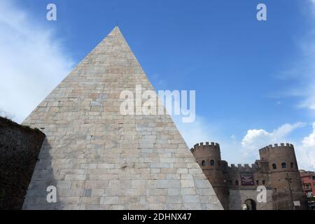 A view of the restored Pyramid of Cestius in Rome,Italy on February 3, 2016. Eternal City's only surviving pyramid dating from conquest of Egypt looks to attract more visitors after extensive clean-up funded by Japanese clothing magnate. Archaeologists are eager to show off the monument, constructed some 2,000 years ago as the burial tomb for a Roman praetor, or magistrate, named Caius Cestius. The pyramid is one of four known to have been built in ancient Roman days, but the only one to survive until today. Their construction reflected a fashion for Egyptian style in Rome after the conquest o Stock Photo