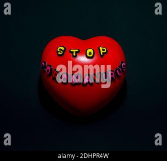 Red heart with the words stop coronavirus, on a black background. Stock Photo