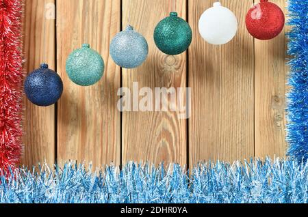 New year's decoration on a wooden background with colorful balloons and a festive garland. The theme of a greeting card with space for text. Stock Photo