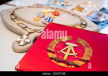 Kirchheim Unter Teck, Germany. 11th Dec, 2020. The Kfz Stander Erich Honekers as a party and chairman of the council of state of the GDR (right) is next to the chain of orders of the white rose of Finland for heads of state (left) and various award medals of the GDR (above) from the Honekers possession. After the conclusion of a legal dispute with the Federation, the Andreas Thies Auction House will auction off numerous orders and state gifts from the estate of the former head of state council of the GDR, Erich Honecker. Credit: Tom Weller/dpa/Alamy Live News Stock Photo