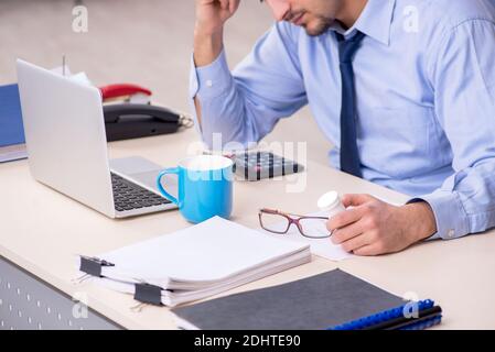 Sick male employee suffering at the workplace Stock Photo