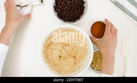Chocolate Chip Cookie batter close up in a bowl on white kitchen table. Stock Photo
