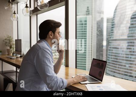 Pensive Caucasian man work on laptop thinking Stock Photo