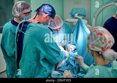 Physicians in Surgery looking down at patient Stock Photo