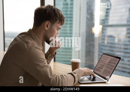 Pensive young man work on laptop thinking Stock Photo