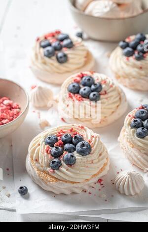 Creamy mini Pavlova with meringue and fresh berries on baking paper Stock Photo