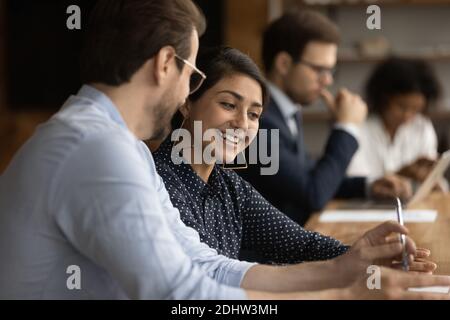 Smiling diverse colleagues work together at workplace Stock Photo