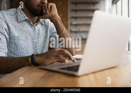 Close up of biracial man working on laptop Stock Photo