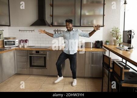 Overjoyed African American man dancing in new kitchen Stock Photo