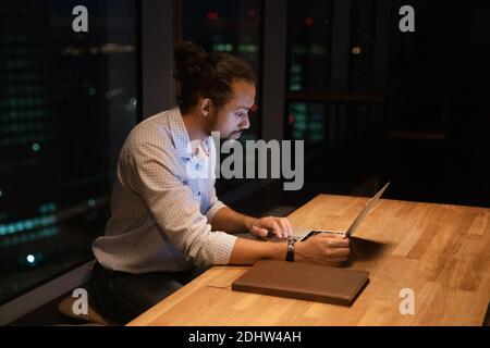 Focused biracial man worker stay in office late Stock Photo