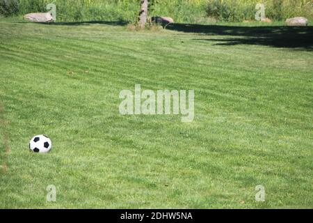 Big geen field with Soccer ball on ground. In the right part of the image space for text on the grass Stock Photo