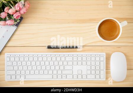 A minimal business workspace with white wireless computer mouse and keyboard with coffee in a white ceramic cup. Stock Photo