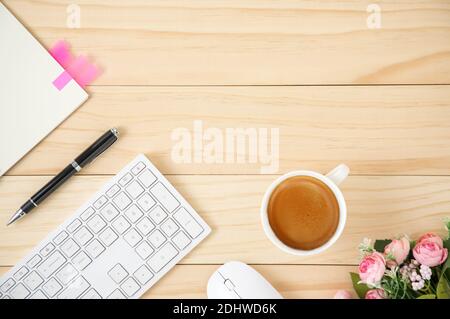 A minimal business workspace with white wireless computer mouse and keyboard with coffee in a white ceramic cup. Office table viewing from above with Stock Photo
