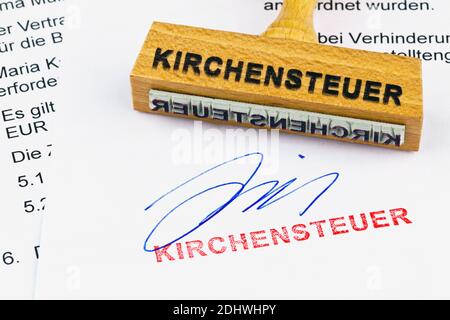 Ein Stempel aus Holz liegt auf einem Dokument. Aufschrift Kirchensteuer