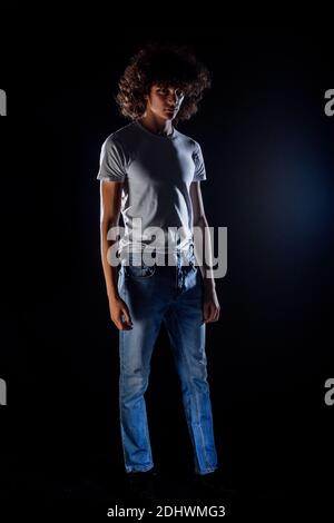 Skinny rock guy wearing  blue jeans pants isolated on black backgorund Stock Photo