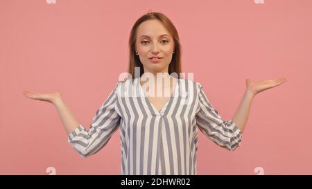 Young caucasian woman with outstretched hands like holding something isolated on pink background. Copy space. High quality photo Stock Photo