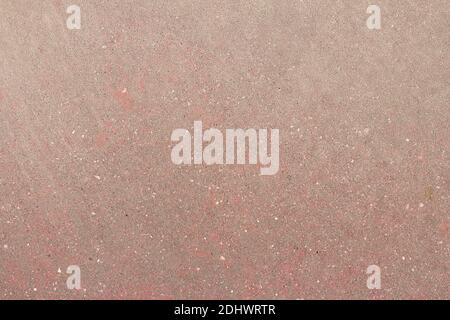 Red concrete and worn ground stained with gray dirt and white spots. Background texture. Abstract art. Stock Photo