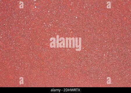 A wall of different types of stone and sand. Red texture background with some small white spots and dirt. Abstract art. Stock Photo