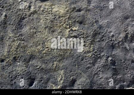 Aerial view of a cracked landscape of earth, rock, and sulfur with relief and holes. Artistic texture background. Stock Photo