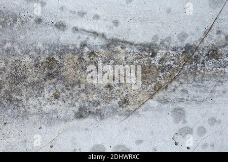 Effects of humidity on white concrete as a textured background. Wall with scratches and a large brown and gray stain. Abstract art. Stock Photo