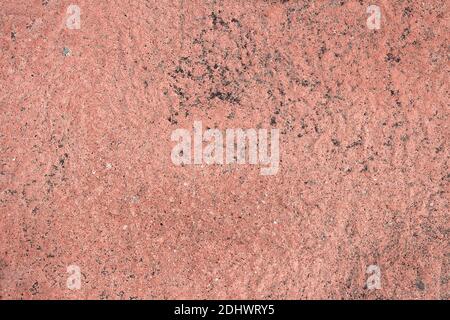 Rough reddish stone and sand texture background with black spots of ash. Overhead view of an abstract landscape. Stock Photo