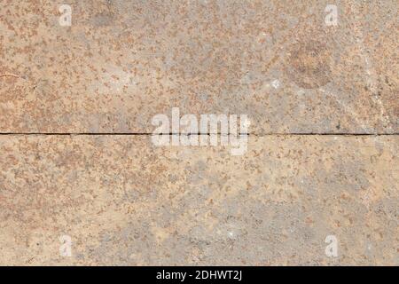 A metal sheet covered in rust and sand is divided into two by a straight line. Abstract texture background. Stock Photo
