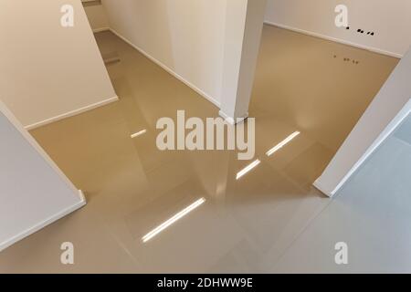 LAREN, THE NETHERLANDS - MAY 16, 2012: An indoor floor with a freshly added coating layer to create a synthetic cast floor installation. Stock Photo