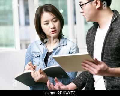 young asian man and woman discussing business in office using digital tablet Stock Photo