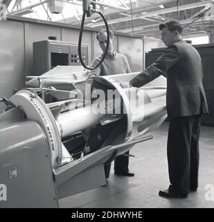 1960s, historical, two aviation engineers at the Short Bros factory in Northern Ireland, with a model of or prototyep of a jet engine. Based in Belfast, Short Brothers were a leading aviation and engineering company in post-war Britian. Stock Photo