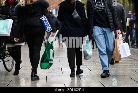 12 December 2020, Hessen, Frankfurt/Main: People walk along the Zeil shopping street with shopping bags. Photo: Andreas Arnold/dpa Stock Photo
