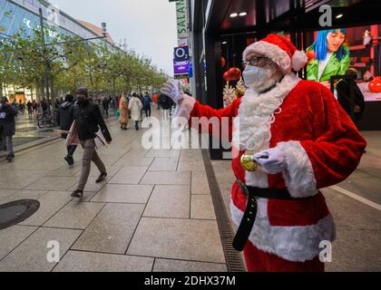 12 December 2020, Hessen, Frankfurt/Main: A Santa Claus greets the people on the Zeil shopping street. Photo: Andreas Arnold/dpa Stock Photo
