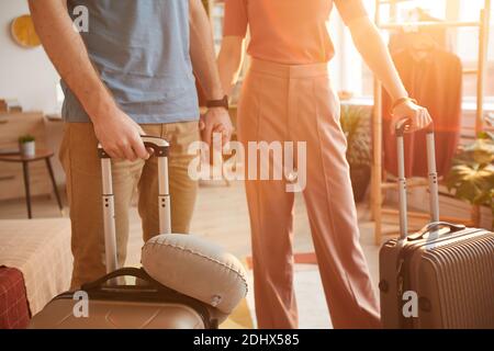 Close-up of young couple standing with luggages in the room they are going to travel Stock Photo