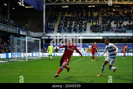 Fans can be seen watching from the stands as Reading's Lago Tomas Esteves (left) attempts to clear the ball away from Queens Park Rangers Niko Hamalainen (right) during the Sky Bet Championship match at Loftus Road, London. Stock Photo