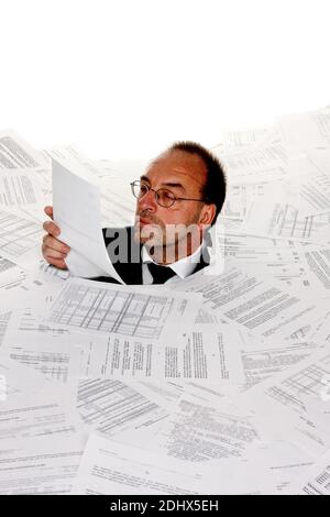 Stress durch zuviel Buerokratie, Mann erstickt in Papier, Insolvenz, Pleite, MR: Yes Stock Photo