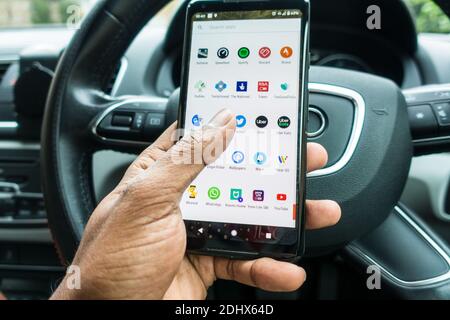 Operating mobile phone behind the wheels of car Stock Photo