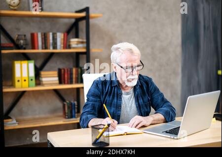 Older man using laptop for studying, working Stock Photo