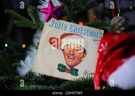 Viersen, Germany - December 9. 2020: Close up of vintage vinyl record cover single with famous Bing Crosby white christmas song in decorated fir tree Stock Photo