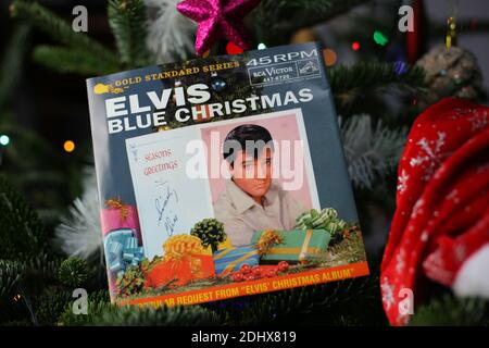 Viersen, Germany - December 9. 2020: Close up of vintage vinyl record cover single with famous Elvis Presley christmas song in decorated fir tree Stock Photo