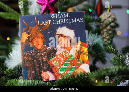 Viersen, Germany - December 9. 2020: Close up of vintage vinyl record cover single with famous Wham last christmas song in decorated fir tree Stock Photo