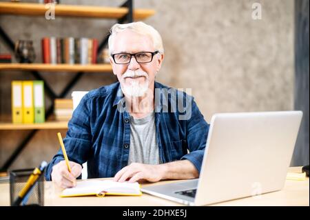 Older man using laptop for studying, working Stock Photo