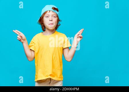 Red-haired boy grimaces gesturing with his hands showing in different directions  Stock Photo