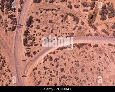 Aerial view of people cycling on a dirt path in the island of La Graciosa, Lanzarote, Canary Islands. Spain. Outdoor trekking route. Explore Stock Photo