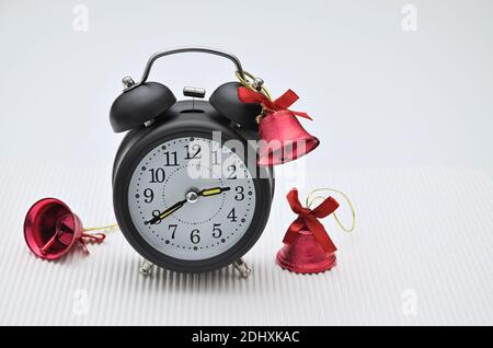 close up of a black retro alarm clock with three red bells, isolated on white background Stock Photo