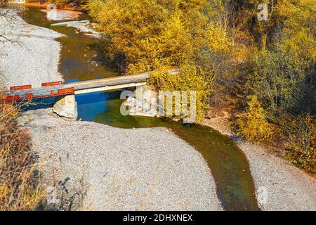 Mountain landscape with a small mountain river with a bridge over it in a deep gorge in the Republic of Adygea in Russia. Stock Photo