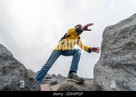 woman hiker climbing over rocks Stock Photo